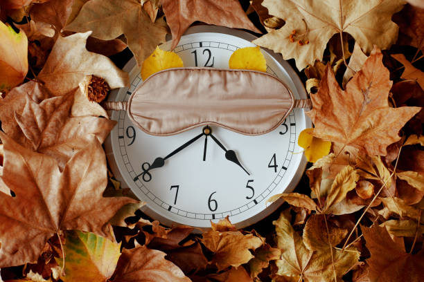istock autumn background with clock, sleeping mask and leaves 1716932965