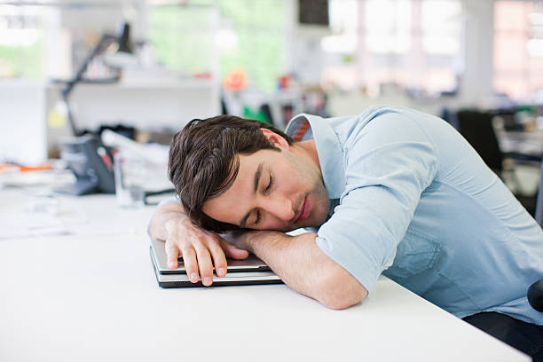 geschäftsmann schlafen auf laptop am schreibtisch in büro - asleep on the job stock-fotos und bilder