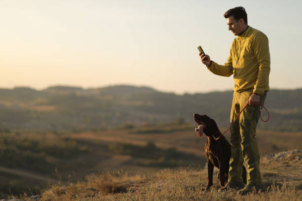 istock Beautiful  German Shorthaired Pointer dog and its owner during outdoors obedience training session. Sit and stay command. Man with hunting dog portrait. stock photo 1716961534