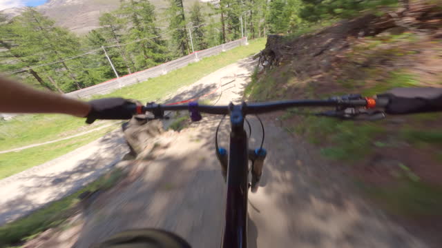 First person view of mountain biker descending trail in the forest