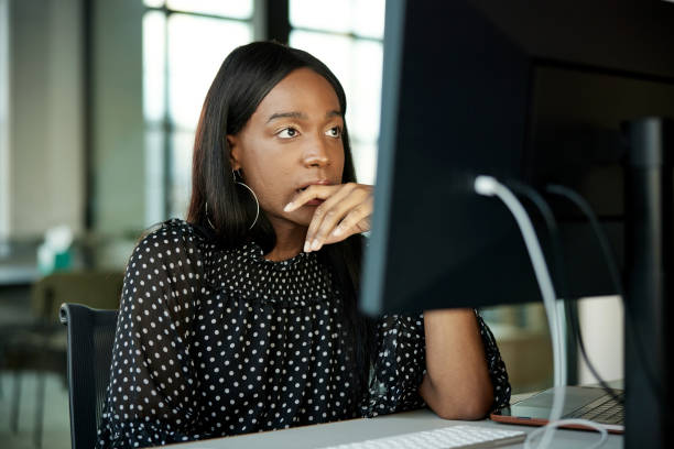 Contemplative office worker staring at desktop pc monitor