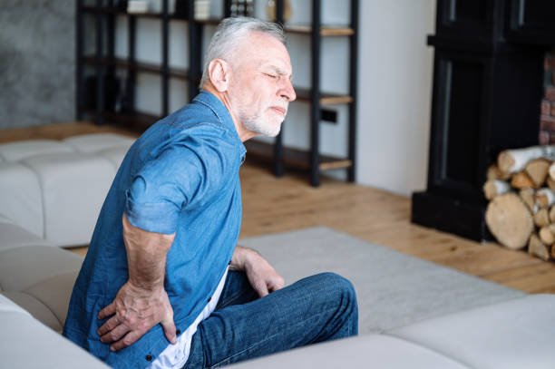 starszy mężczyzna odczuwa ból i osteochondroza lędźwiowa, zapalenie - backache lumbar vertebra human spine posture zdjęcia i obrazy z banku zdjęć