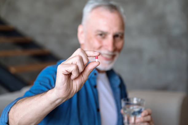 Selective focus on medical pill in mature man hand
