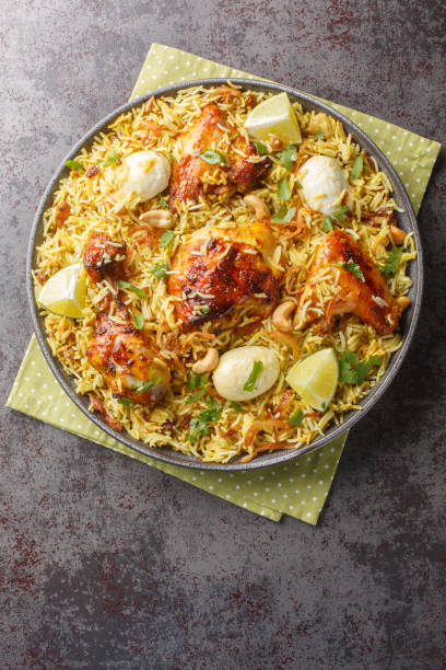 istock Spicy chicken biriyani rice with sliced eggs closeup on the plate. Vertical top view 1716975605