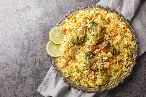 Pilaf Kachchi biryani is a popular meal served at parties, celebrations, and weddings closeup on the plate on the table. Horizontal top view from above