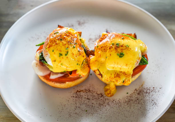 istock English muffin with poached eggs, bacon and Hollandaise sauce with vegetables 1716976171