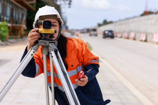 die ingenieure verwenden theodolitengeräte für die routenvermessung, um eine brücke über die kreuzung zu bauen, um verkehrsstaus während der hauptverkehrszeiten zu reduzieren. - construction safety mid adult men road construction stock-fotos und bilder