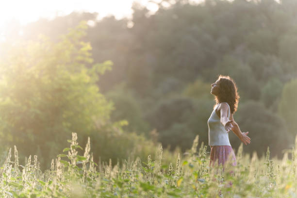 istock Young woman meditating in a serene meadow 1717005219