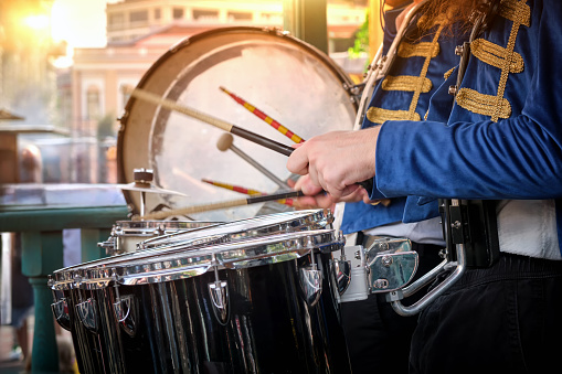 A brass band plays in a city park. Close-up of the drums in the foreground.
