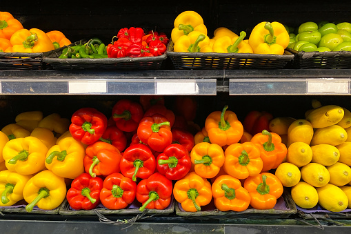 Fresh organic vegetables neatly arranged on a supermarket shelf, showcasing vibrant colors and natural beauty, ready to be selected by health-conscious shoppers.
