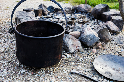 Country kitchen outdoors witch's cauldron metal pan for cooking outdoors in the middle of nature near the campfire campfire cooking traditional dishes