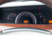 Car dashboard with red instrument circles with backlit arrows at night with a speedometer, tachometer with a to monitor the condition of the car on a black background.