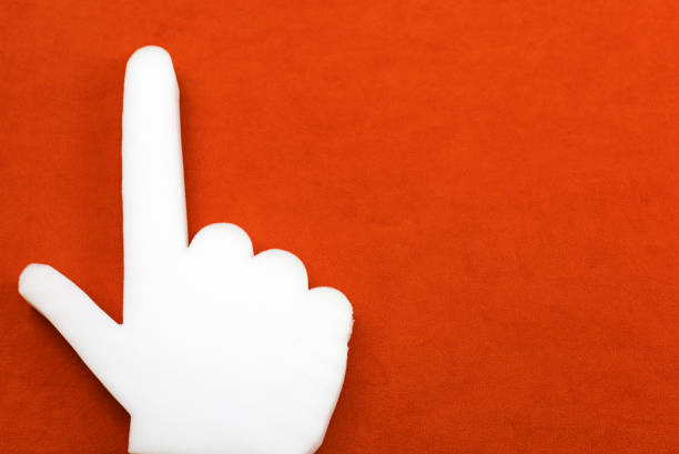a hand made of foam rubber with an index finger on a red background