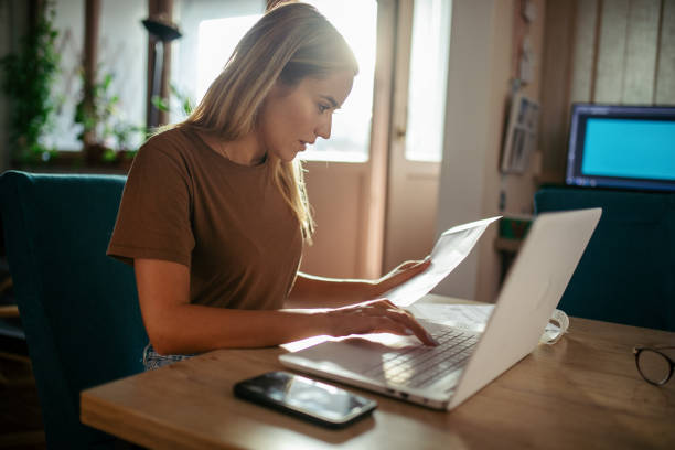 istock Young woman planning budget at home using lap top 1717047406