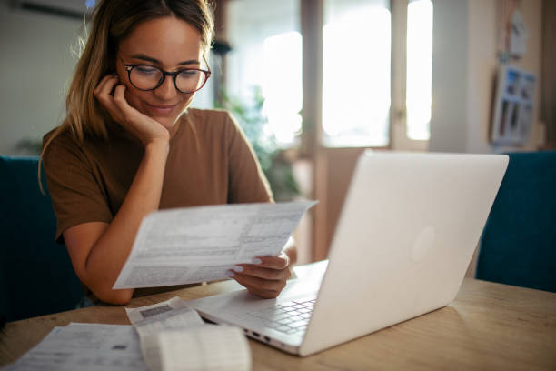 istock Young woman planning budget at home using lap top 1717048057