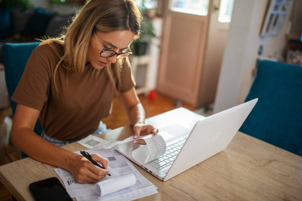 istock Young woman planning budget at home using lap top 1717049157