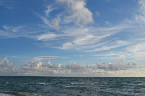 istock Sea waves, sandy ocean shore, blue sky with white clouds 1717060589