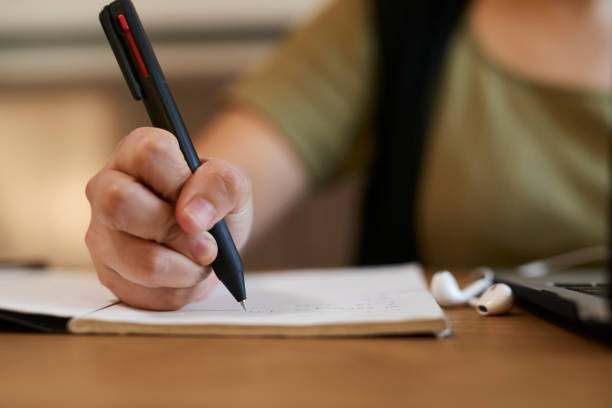 istock Asia young woman writing in notebook with laptop. 1717072565