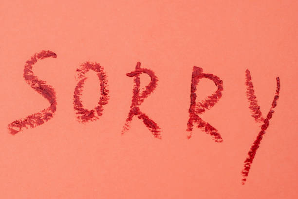 istock Sorry - red lipstick lettering on pink 1717073668