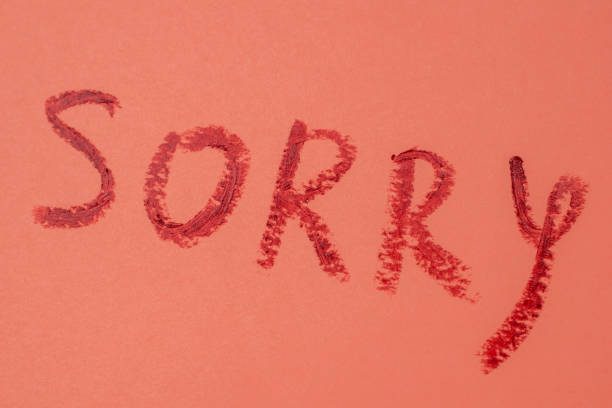 istock Sorry - red lipstick lettering on pink 1717074173