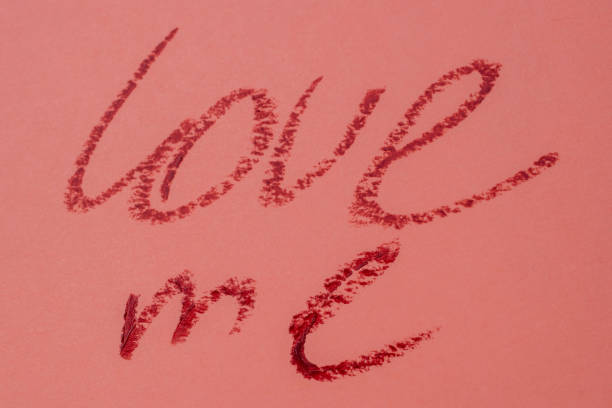 istock Love me - red lipstick lettering on pink 1717077514