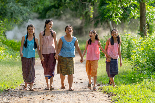 Group of Asian young girl wear traditional clothes walk with happiness together on road.
