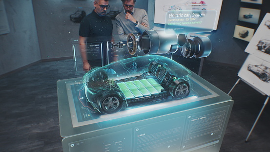Two male automotive engineers develop new eco-friendly electric car using futuristic augmented reality holographic automobile prototype. 3D graphics of vehicle high-tech developing. VFX animation.
