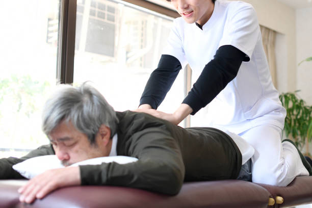istock Chiropractor massaging shoulders and back and male patient lying on massage bed 1717086194