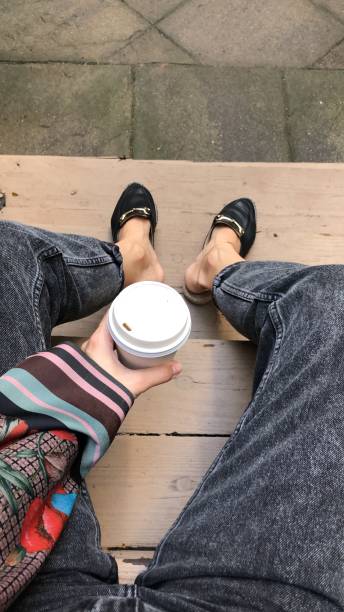 istock A cup of coffee in hand sitting on the steps in a yard 1717087398
