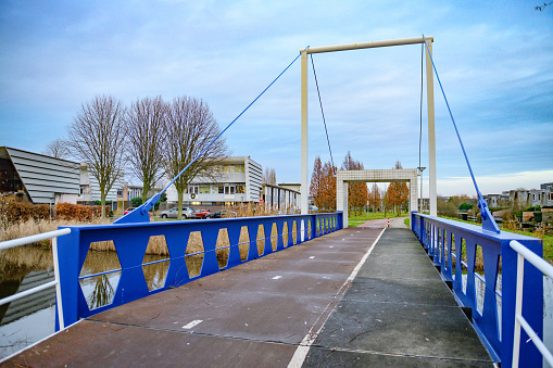In Amsterdam, Netherlands a  pedestrian bridge with bike lanes is open empty in a residential district.