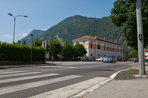Close-up of pedestrian crossing, crosswalk and traffic light in the Italian town of Canso in Lombardy, with the Alps mountains in the background. Italy
