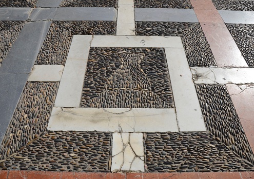 Floor of geometric shape made with cobbles and marble in the Old Town of Seville, Spain.