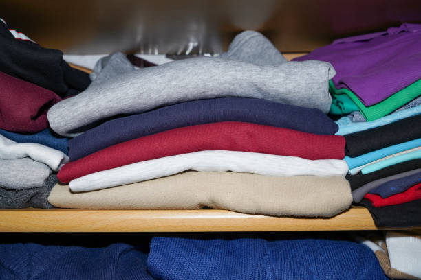 istock Wardrobe overflowing and colorfully mixed with jackets and pants, sweaters 1717118403