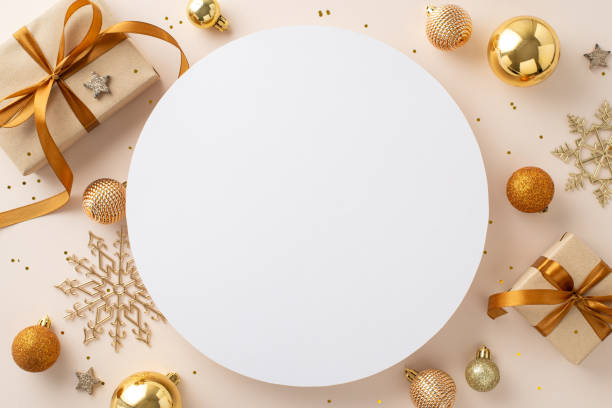 istock Embrace New Year with elegance! Top view gift boxes with satin bows, chic tree ornaments, shiny stars, snowflakes, glitter arranged on soft pastel backdrop, providing circular space for your message 1717119048
