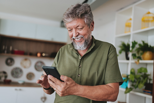 Portrait of a senior man using smartphone at home