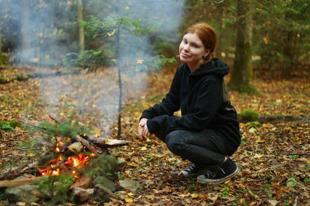 istock a girl warms her hands by the fire 1717120367