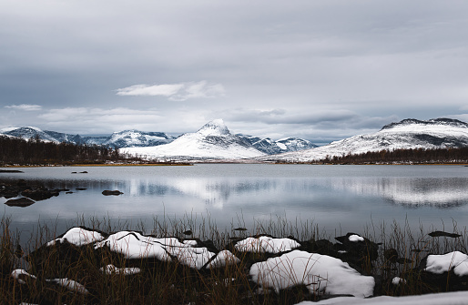 Beautiful winter landscape with snow covered mountains and lake in North Finland