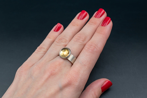 A captivating vintage ring adorns a woman's hand in this alluring promotional photo, embodying the essence of old-world elegance. Perfect for an online jewelry store's exquisite collection.