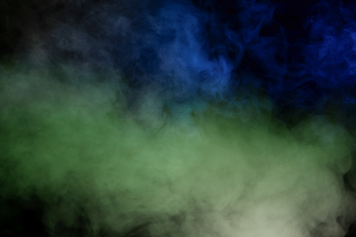 Green and white steam on a black background. Copy space.