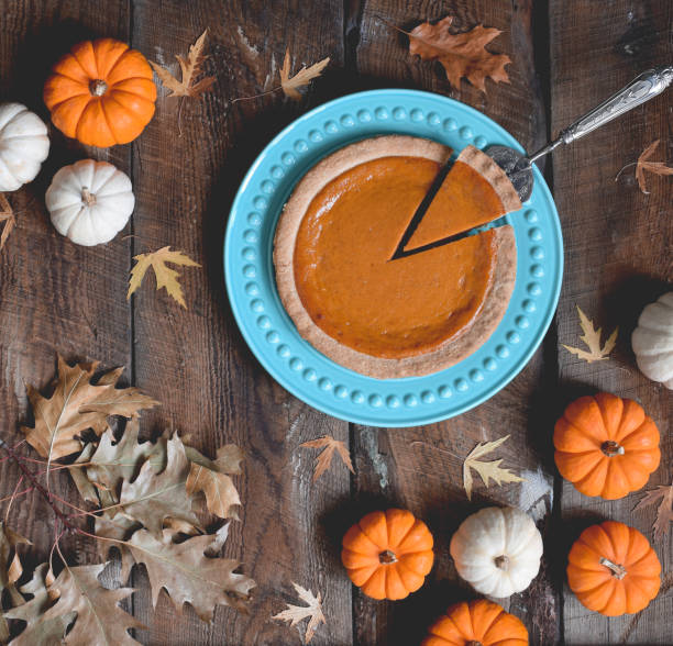 istock Top view of pumpkin pie on plate surrounded by mini pumpkins 1717162593
