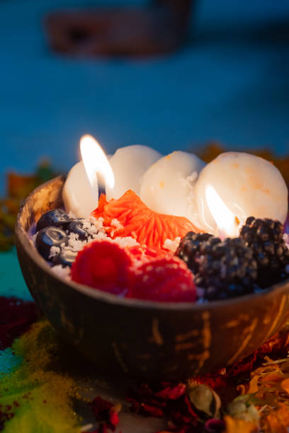 candle looking like fruit bowl in coconut shell  with diya lamps in the background on festival of diwali stock photo