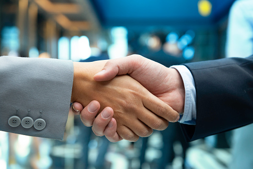 Closed up hands of business partners making firm handshake after meeting for merger and acquisition concept