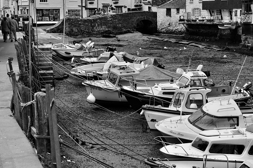 Black and white image of the picturesque harbour of Polperro with its ancient smuggling heritage is still a busy fishing harbour today and a tourist hot spot.