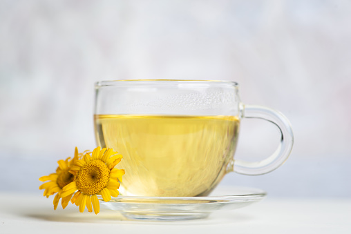 Herbal tea with yellow flowers on a white background
