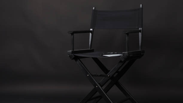 istock Director chair with clapper board on black background. 1717283800