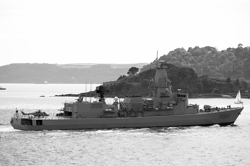 Navy frigate enters a harbour after offshore training exercises.