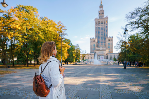 Woman looking at Palace of Culture and science in Warsaw, Poland