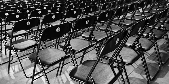 rows of black empty chairs in entertainment hall for design purpose