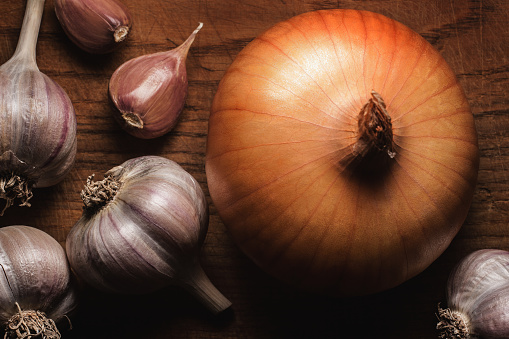 Garlic and onion on wood table, still life.