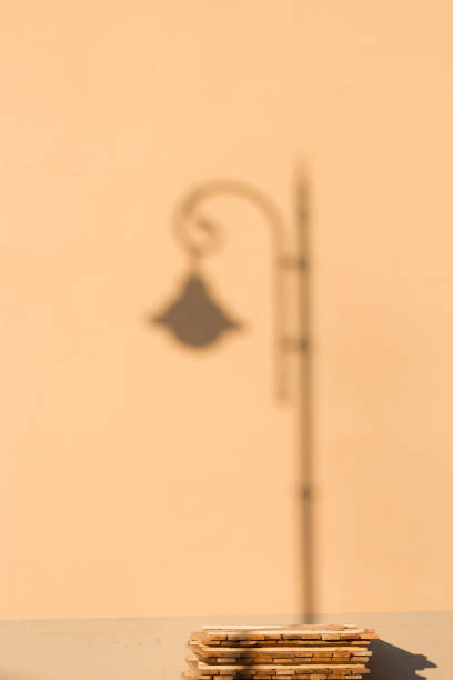 city lamp shadow on the wall near the stack of wooden details